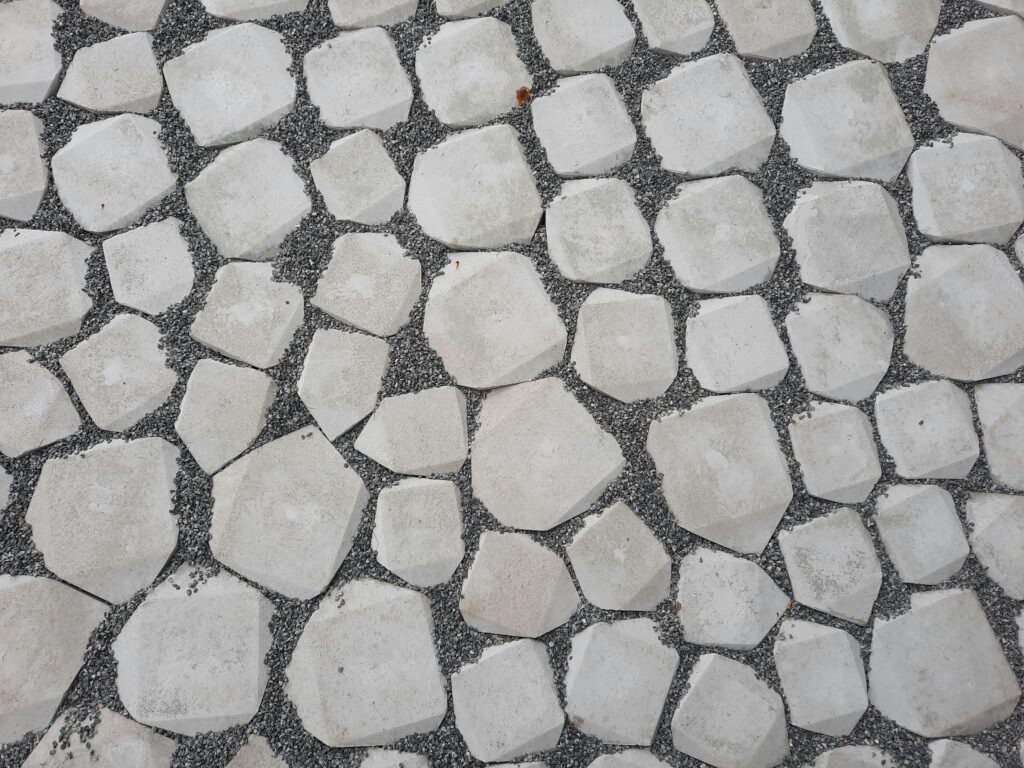 Top view of a geometric stone pathway with white rocks and gravel.