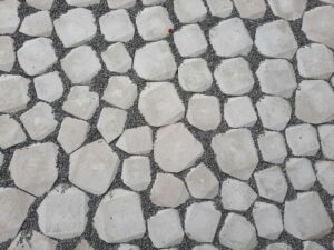 Top view of a geometric stone pathway with white rocks and gravel.