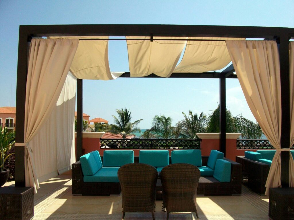 Elegant outdoor seating area on a sunlit rooftop overlooking the ocean.