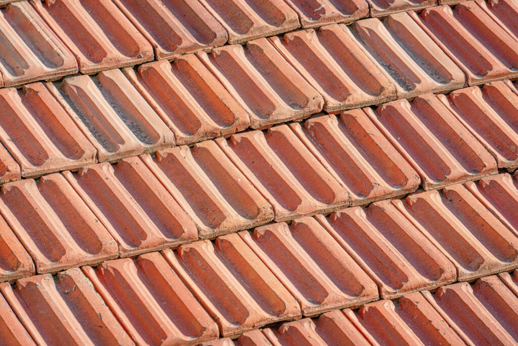 Detailed view of overlapping terracotta tiles forming a textured rooftop surface.