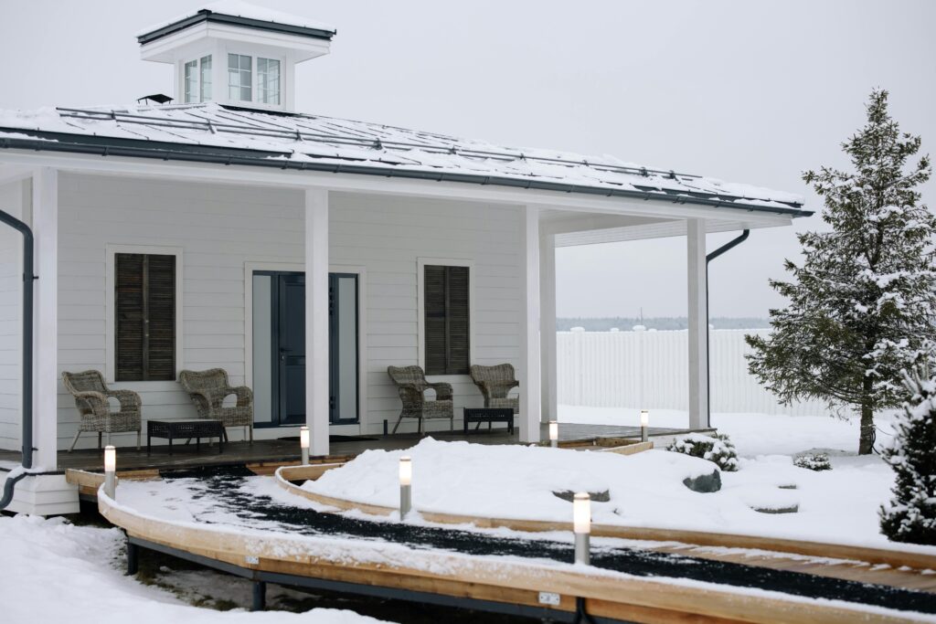 A cozy modern cabin surrounded by snow, featuring a stylish exterior design.