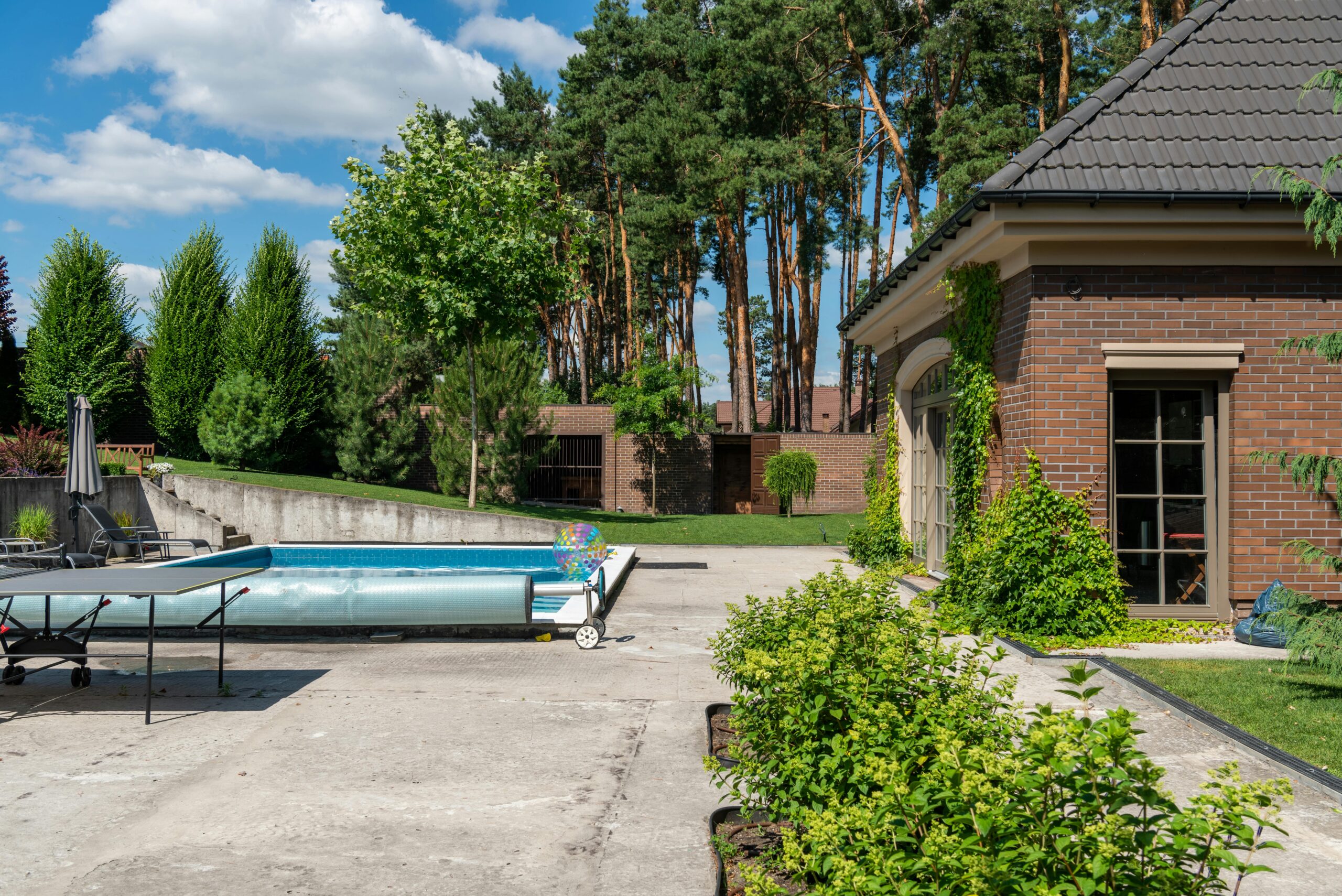 Beautiful suburban house with a private pool and lush greenery, perfect for summer relaxation.