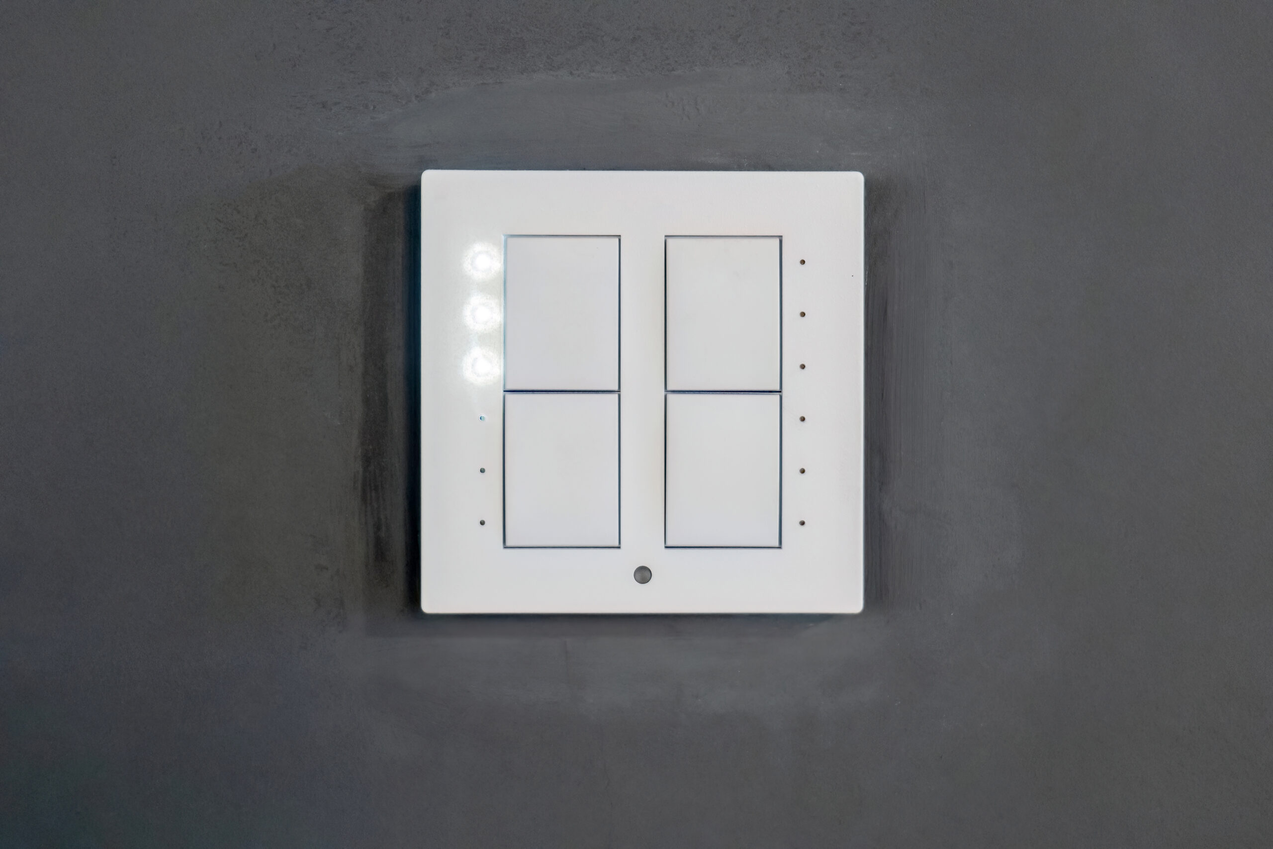 A modern interior wall featuring a sleek, minimalist smart light switch with a glowing LED indicator