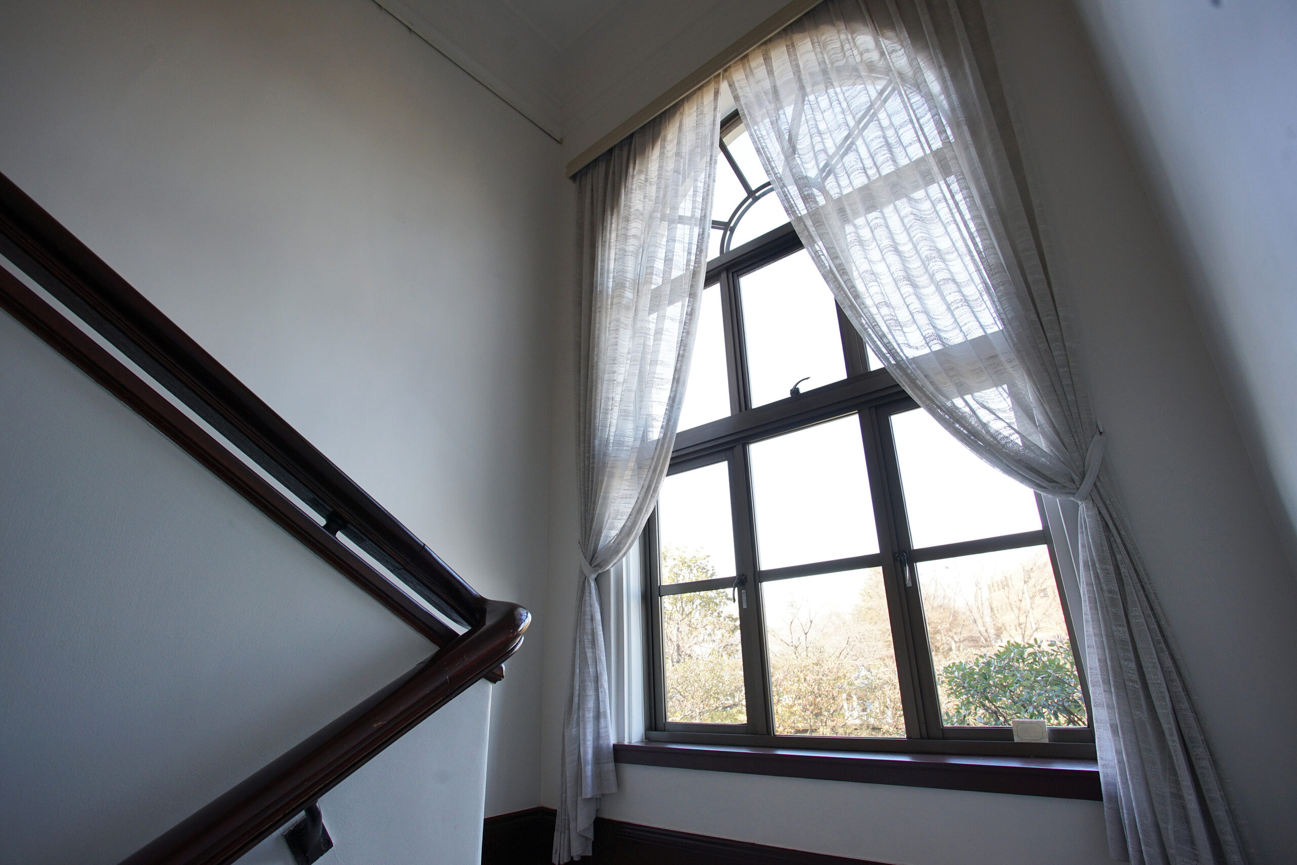Hard-to-reach high window with stylish Roman shade treatment