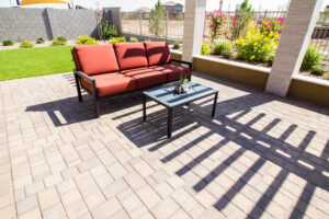 cool paver ideas using light-colored travertine on a sunny backyard patio