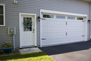 Clean and organized garage entryway with a man door and decorative exterior details