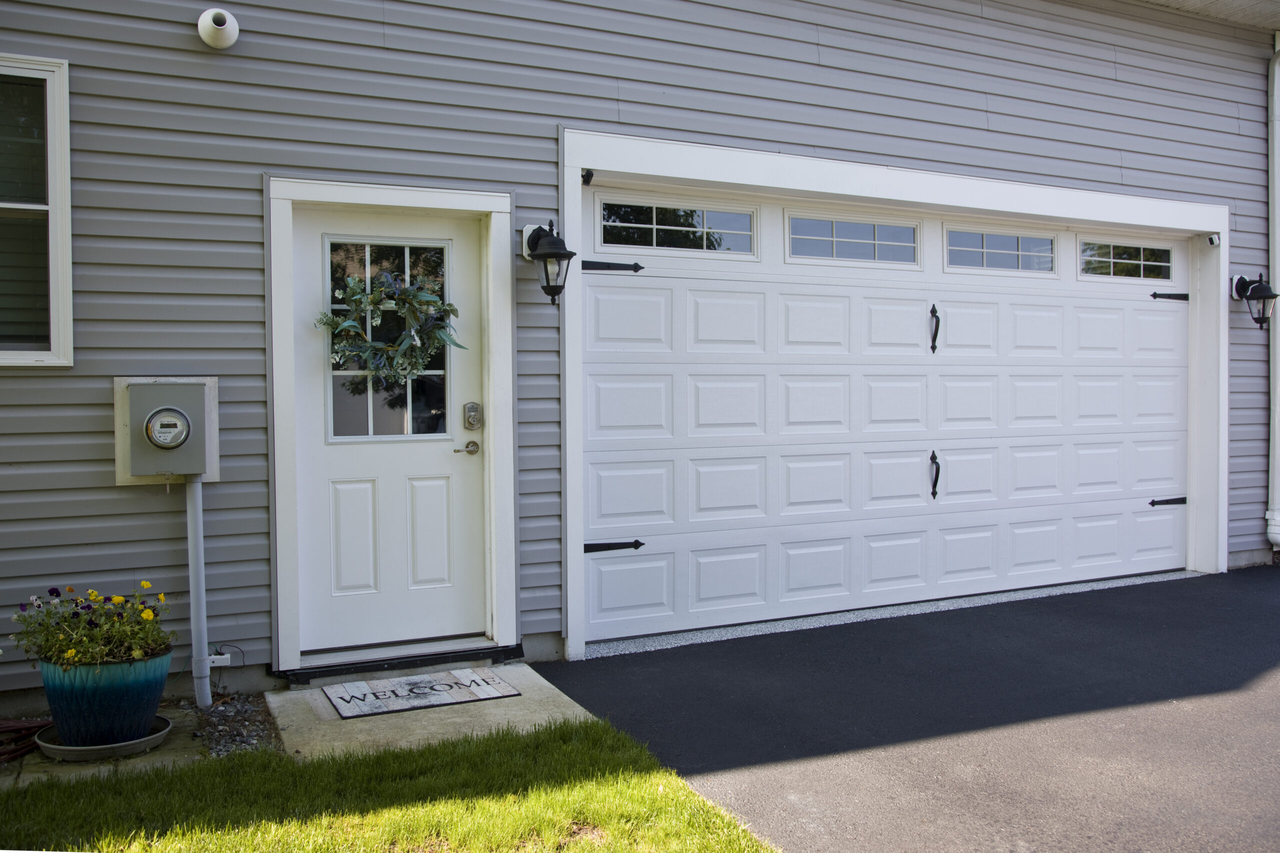 Clean and organized garage entryway with a man door and decorative exterior details