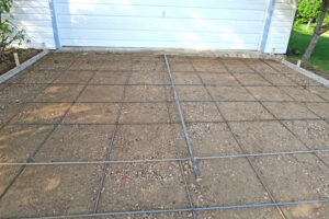 rebar grid laid over gravel and soil base showing how soil type affects concrete installation before pouring