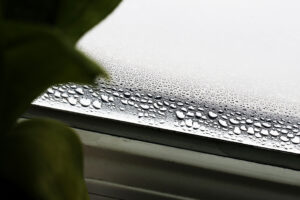 Condensation on interior window glass inside a home during cold weather