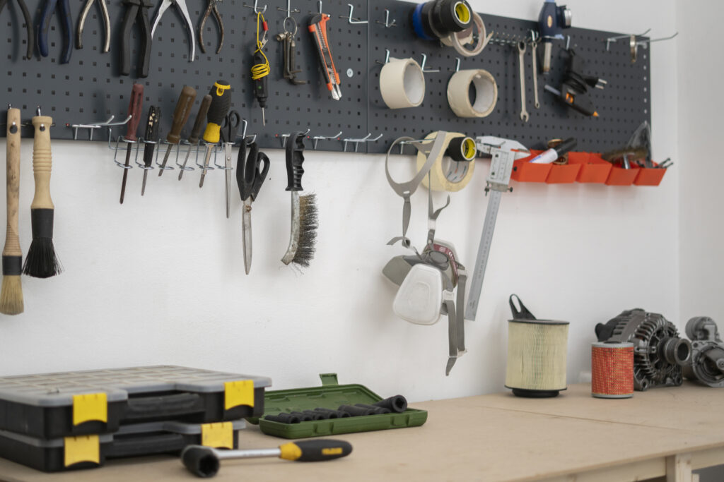 Organized garage with wall-mounted pegboard and labeled storage zones, showing a garage organization layout