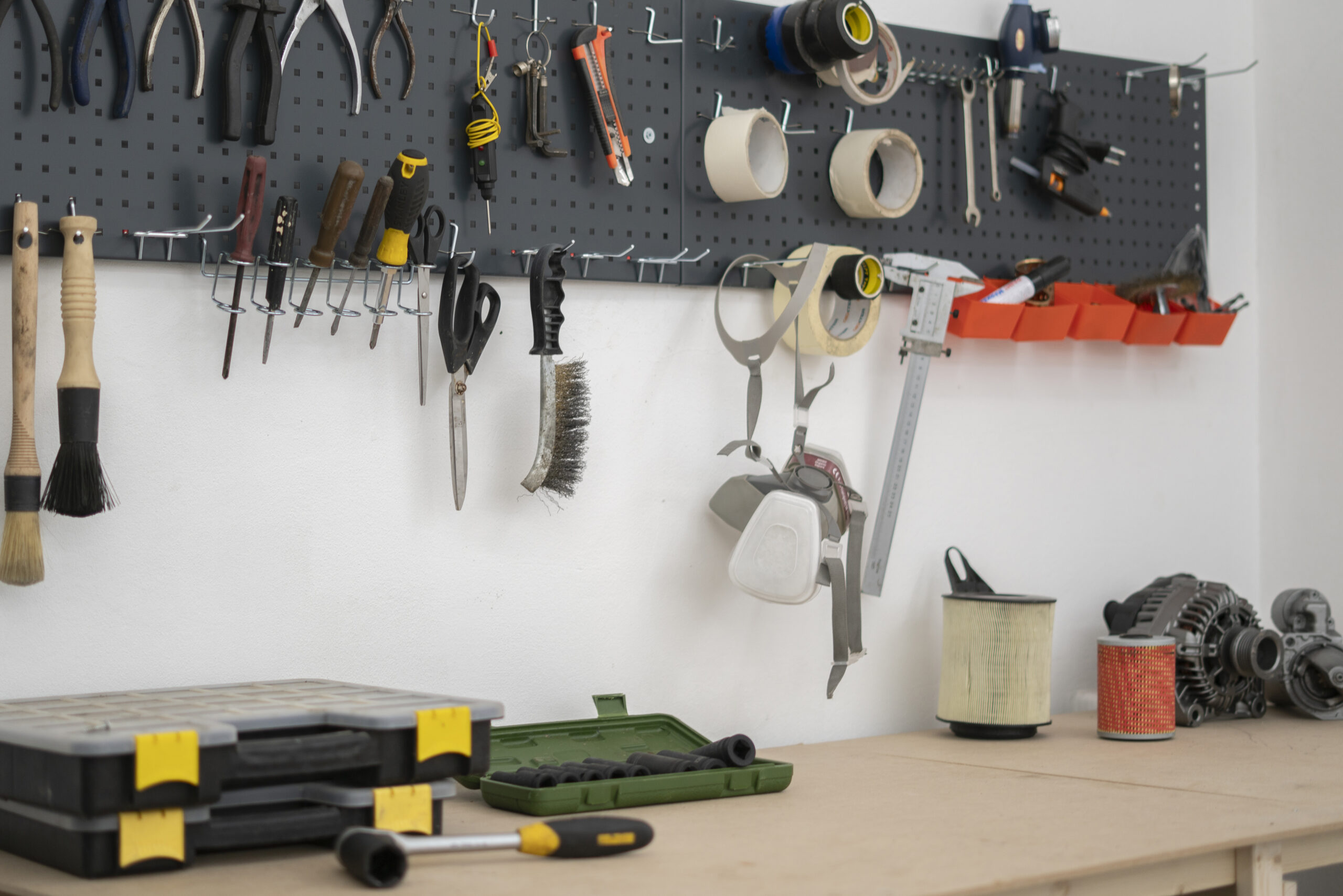 Organized garage with wall-mounted pegboard and labeled storage zones, showing a garage organization layout