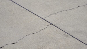 uneven concrete repair showing a sunken driveway slab with visible cracks and settling