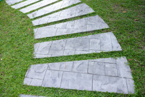Curved paver pathway through a backyard garden, an example of pavers for backyard flow