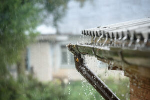 Residential roof and gutter system directing rainwater away from the home