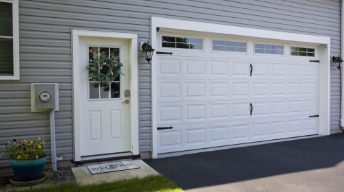 Clean and organized garage entryway with a man door and decorative exterior details