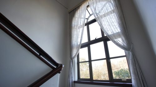Hard-to-reach high window with stylish Roman shade treatment