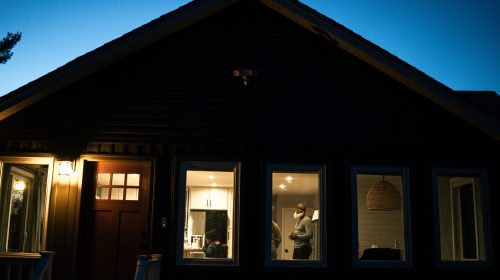 Illuminated home interior visible through a window at night from outside