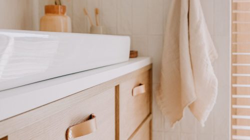 A modern bathroom features a stylish wooden vanity with ample storage and a pristine white sink