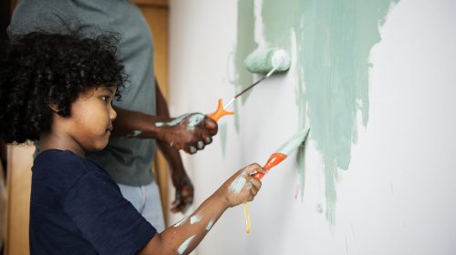 Black family painting house wall