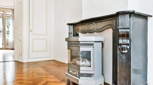 Interior design of empty luxury retro styled room with classic glass door and parquet floor furnished with fireplace