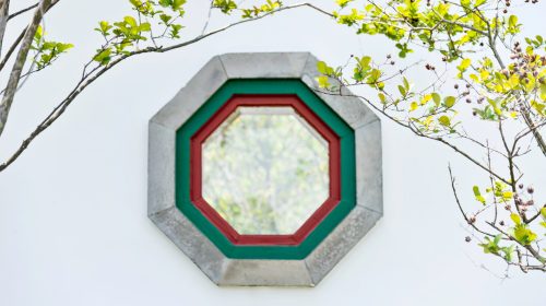 Chinese style hexagonal window and green leaves.