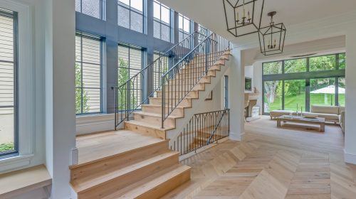 Elegant natural wood flooring and window lined staircase