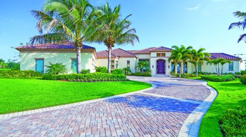 A paver driveway leads to a beautiful estate home in Florida.