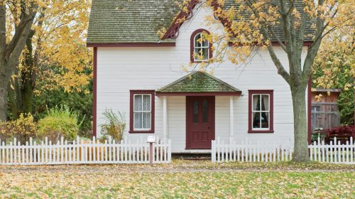Picturesque traditional house with autumn foliage and a white picket fence in London, Ontario.