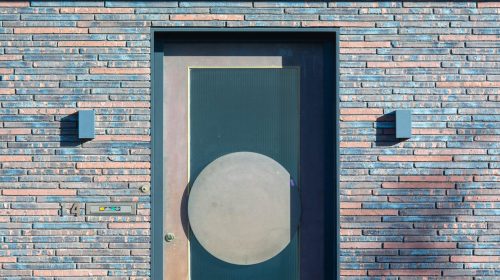 Contemporary brick building facade showcasing a stylish entrance with a geometric door design.