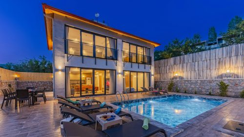 Modern luxury house with a swimming pool under twilight skies, offering serene outdoor living.