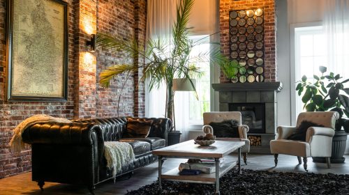 Cozy living room with industrial design featuring brick walls, classic furniture, and chic decor.