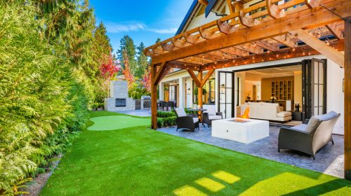 Colorful house with peak roof large windows in autumn fall sunny blue sky and vivid landscaping